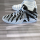 Close-up of a black and light-blue running shoe with a geometric pattern and blue laces on a track surface, with a sock visible above the shoe edge.