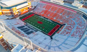 Aerial view of Oklahoma State football stadium with orange seats and the field’s big OSU logo at center field. Oklahoma State Cowboys stadium from above, orange seating, green turf, and a large logo at midfield.